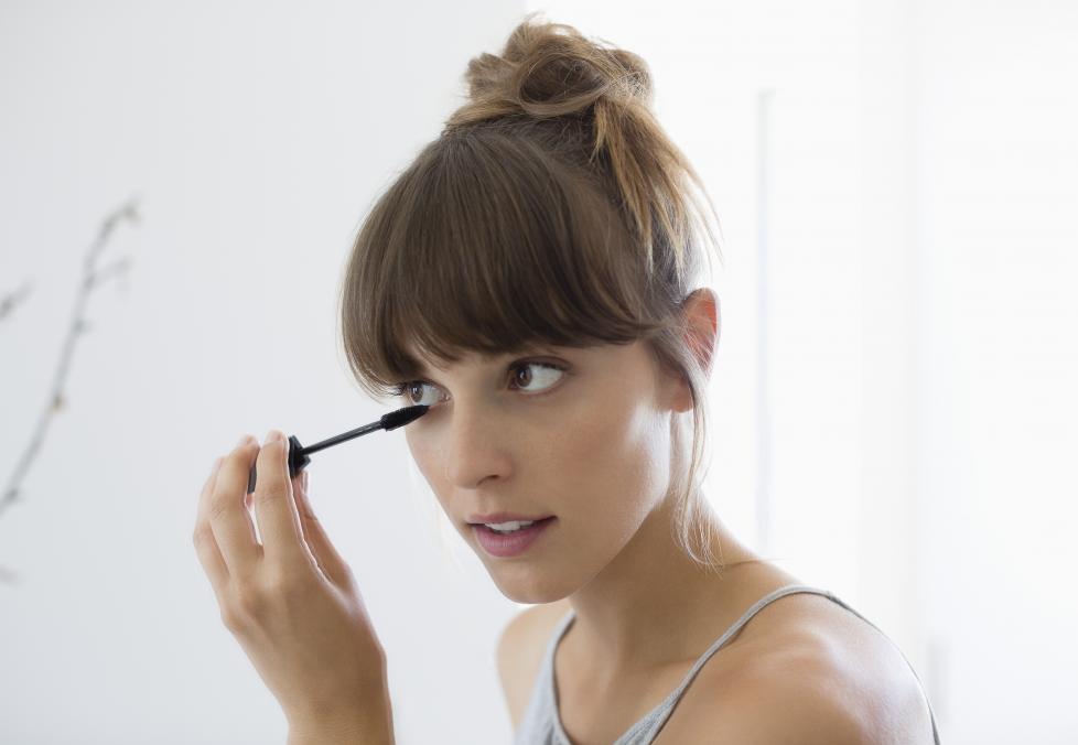 Woman applying mascara