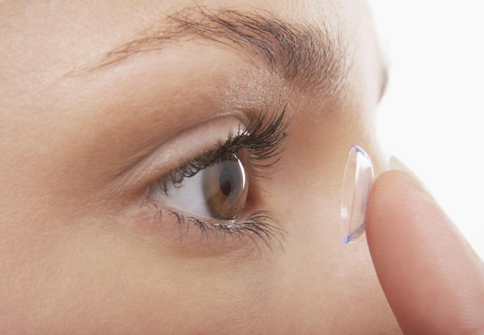 Woman putting in contact lenses.