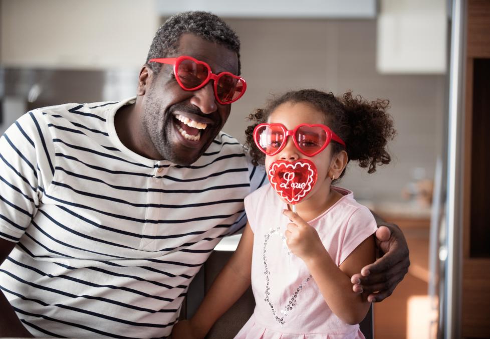 Show your eyes some love like this happy dad and daughter wearing heart-shaped glasses.