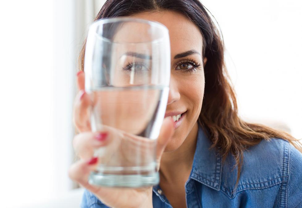 woman looking through a glass of water