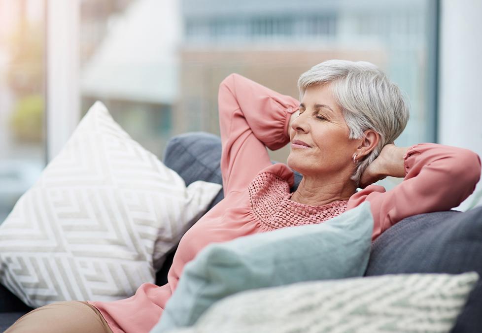 Woman sitting on sofa with eyes closed