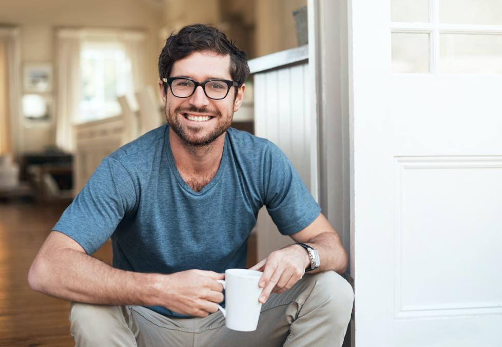 portrait of young adult male wearing glasses drinking coffee