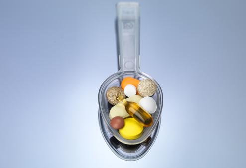 spoon with pills and supplements