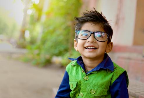A child wearing glasses and smiling.