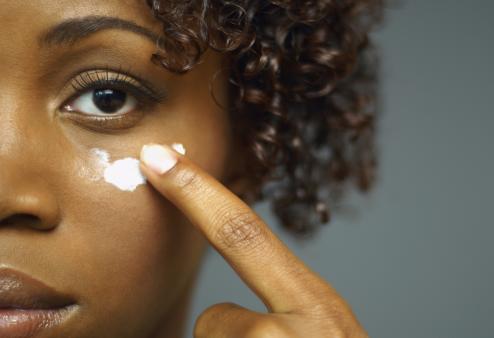 Woman applying eye cream.