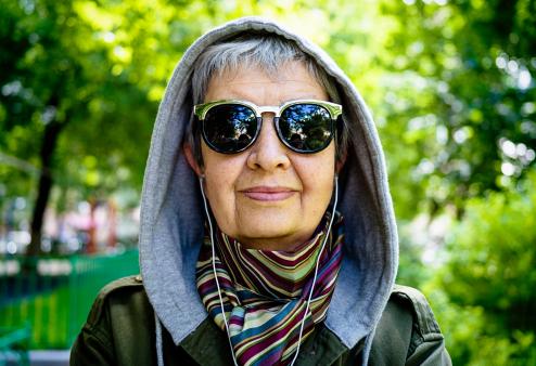 Woman in park wearing sunglasses.