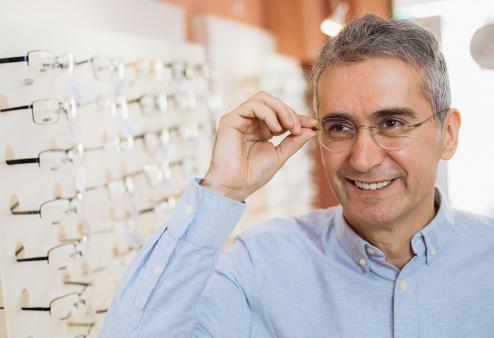 Middle-aged man trying on glasses for a story on the best glasses for square faces