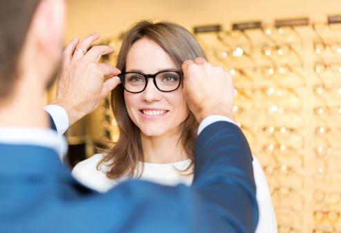 Woman testing new glasses with optician