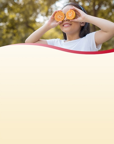 Girl holding orange halves in front of her face