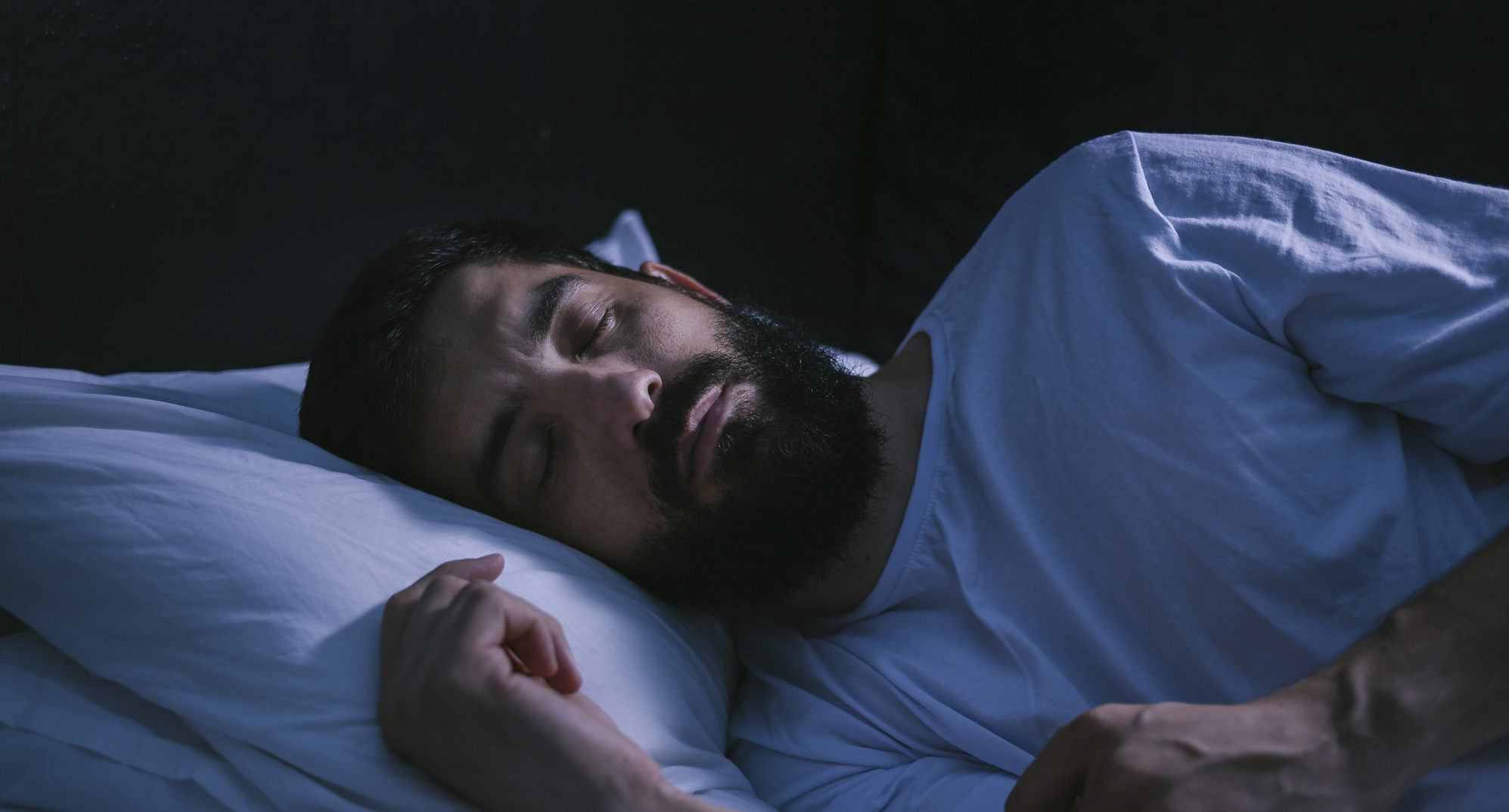 Man with beard sleeping.