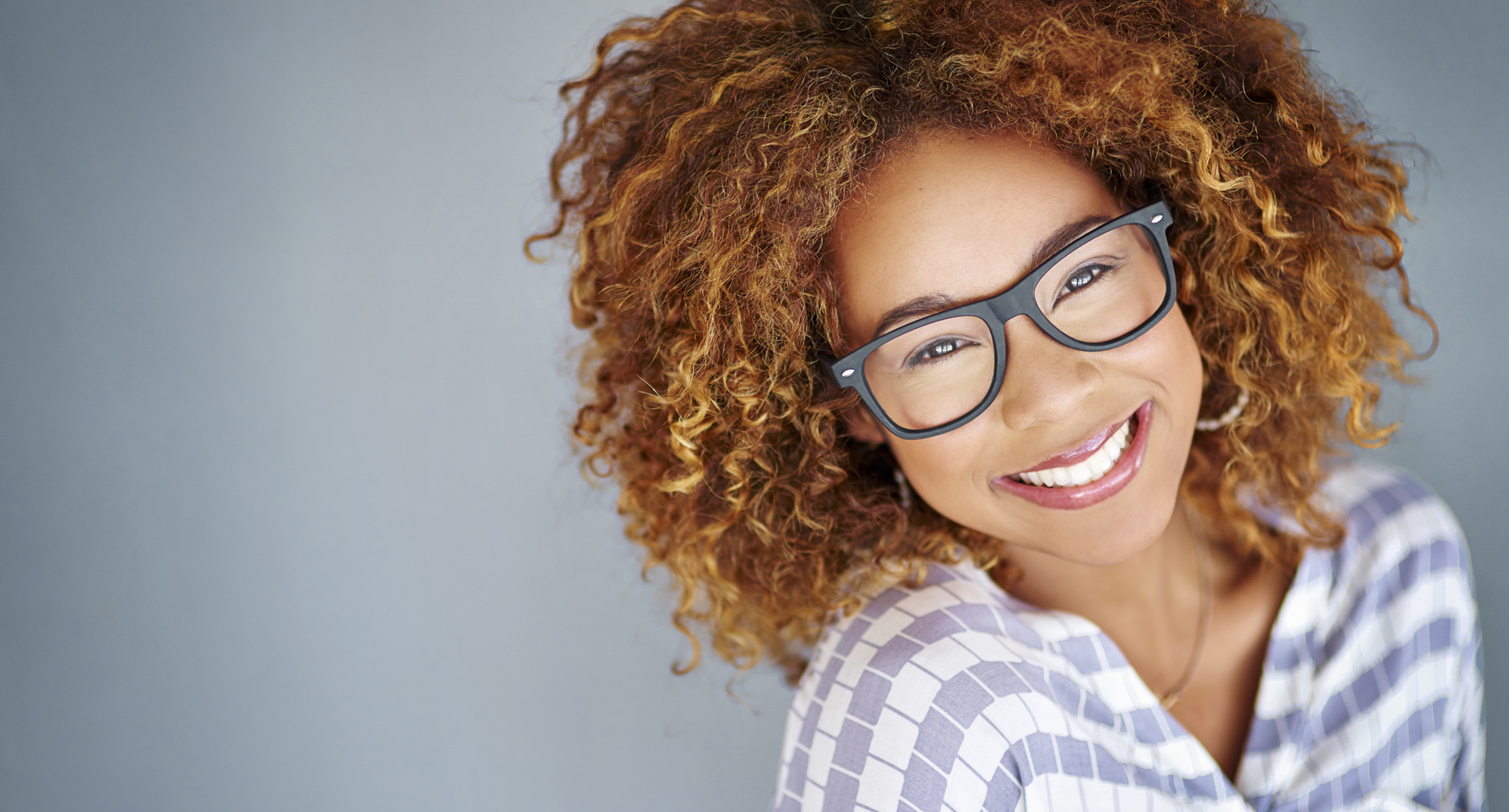 Building an eyeglasses wardrobe doesn't have to break the bank. Woman in stylish frames.
