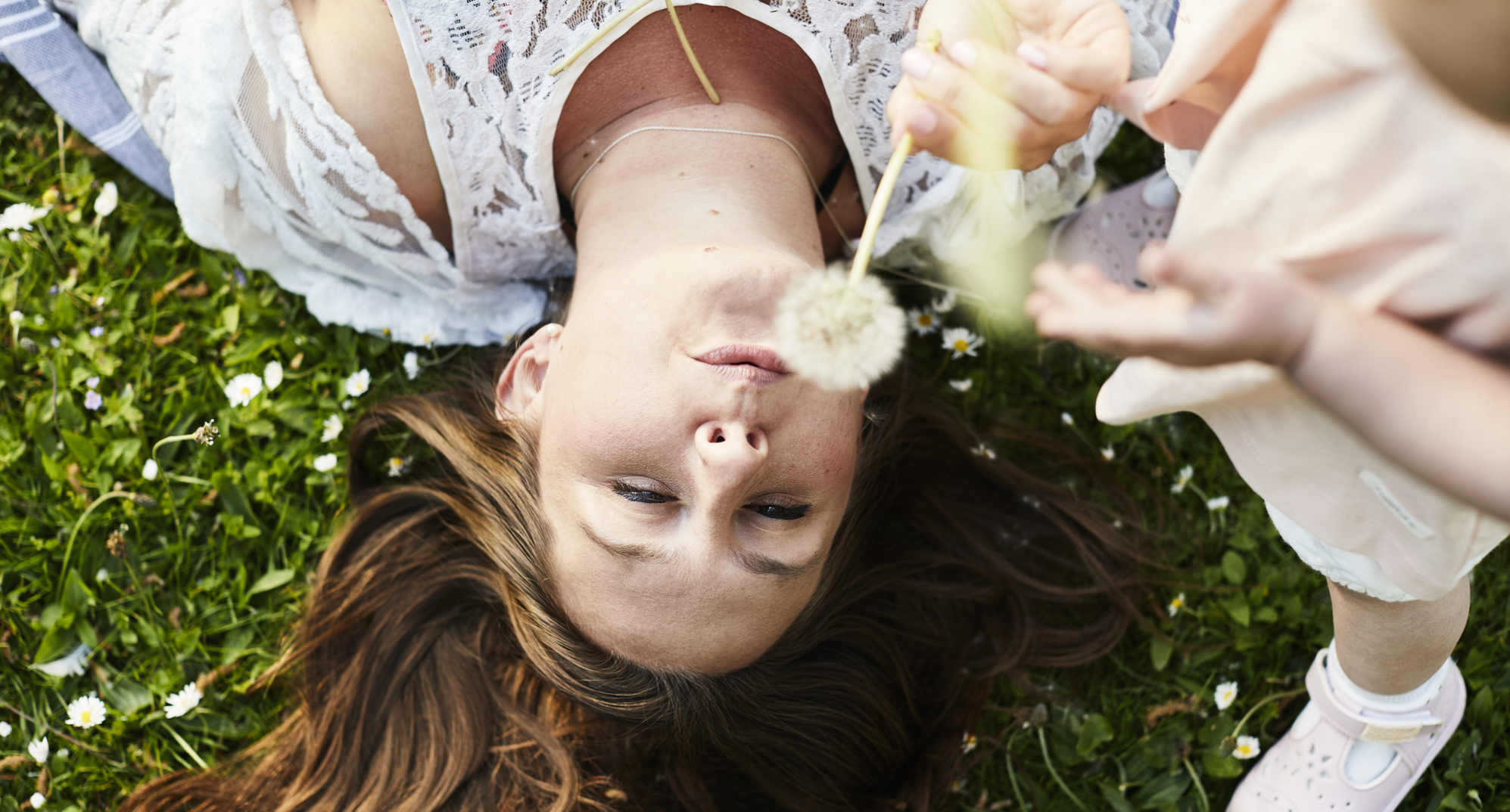 Allergy season is here and your eyes know it. Your America's Best optometrist can help you find relief. Woman in grass blowing a dandelion.